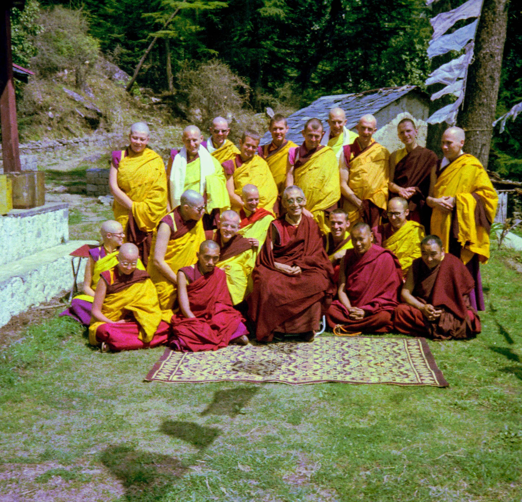 (09311_ng.JPG) Ordination group with HH Trijang Rinpoche, 1976. Front row: Karin Valham, Lama Zopa Rinpoche, HH Trijang Rinpoche seated, Lama Yeshe, Geshe Jampa Wangdu. Second row: Margaret McAndrew, Angeles de la Torre, Steve Malasky (Steve Pearl), Wendy Finster, Thubten Pende (Jim Dougherty), Dieter Kratzer. Standing: Elisabeth Drukier, Scott Brusso, Roger Wheeler, Jeffery Webster, Marcel Bertels, John Feuille, Adrian Feldmann (Thubten Gyatso), Peter Kedge, Gareth Sparham, George Churinoff.