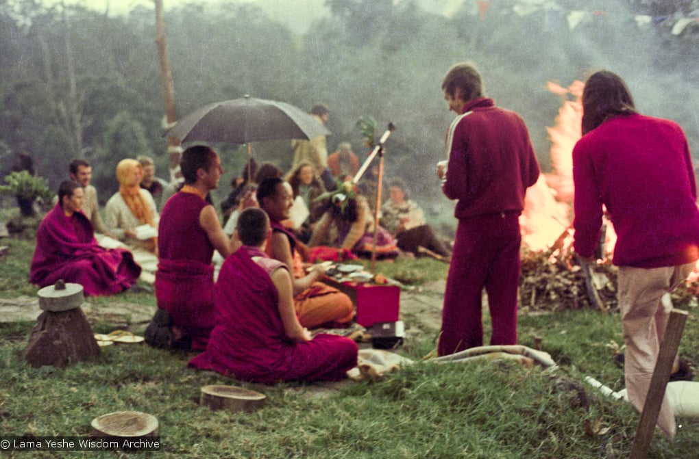 (16053_ng-2.psd) Lama Yeshe doing the Fire Puja (with Jhampa Zangpo (Mark Shaneman) holding the umbrella, Yeshe Khadro (Marie Obst) sitting to his right and Anila Ann sitting to the left, Chenrezig Institute, Australia, 1976.