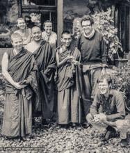 (18950_pr-3.psd) Lama Yeshe and Lama Zopa Rinpoche with students and artists, Tushita Retreat Centre, Dharamsala, India, 1973. Wim (squatting at the front right), the Dutch artist, who had painted the walls of Lawudo Gompa the year before, arrived at Tushita and painted a mural of Guru Shakyamuni on the left front porch wall of the building, while Lawrence Greenberg (standing to the right of Rinpoche) painted the four friends on the right. Suzanne Lee is standing to the left of Lama Yeshe.