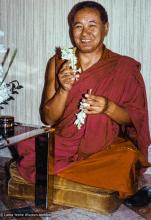 (21951_pr-3.jpg) Lama Yeshe giving the Vajrasattva empowerment, Alhambra, Spain, 1982. "That evening, Lama Yeshe was about to give some students a Vajrasattva empowerment in his room at the Granada Palace Hotel when it was found that his dorje and bell had been left  in Barcelona. No matter, Lama picked up two tuberose spikes and used those instead. At exactly those moments in the ritual when music is offered and the bell usually rung, the bells in the church next door began to chime— every time