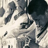 (13300_pr-2.psd) Lama Zopa Rinpoche doing puja (spiritual practice) during the Fourth Meditation Course, Kopan Monastery, Nepal, 1973. Photo by Brian Beresford.