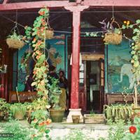 (15182_pr.psd) The painted front veranda at Tushita Retreat Centre, Dharamsala, India. Wim, a Dutch artist who had painted the walls of Lawudo Gompa in 1972, painted a mural of Guru Shakyamuni at Tushita. In 1972, along with a few of their Western students, Lamas Yeshe and Zopa bought an old colonial house on a hill above McLeod Ganj in Dharamsala, India, and there founded Tushita Retreat Centre.