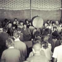 (15883_sl.psd) Photo of the lamas and sangha doing puja in the tent, Kopan Monastery, Nepal, 1974. For the Seventh Meditation Course a huge Indian wedding tent replaced the dusty burlap-walled tent.