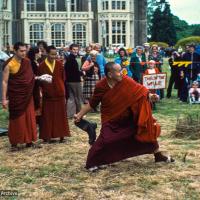 (16697_sl.psd) Among the games staged in the gardens was the rural sport of “wellie wanging.” This consisted of hurling a large rubber Wellington boot as far as possible, from a standing position. Chris Kolb (Ngawang Chotak) and Ven Samten watch Lama Yeshe taking his turn, Festival Day at Manjushri Institute, England, 25th of August, 1979. Brian Beresford (photographer)