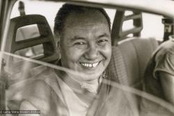 (15264_pr-3.psd) Lama Yeshe leaving Geneva, Switzerland, 1983. Jan-Paul Kool (photographer): "I had taken a lot of photos of Lama over the years and it seemed to me he was much more serious that time in Geneva, less laughing.  That shot of him in the car was his last big smile for me."