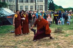 (16697_sl.psd) Among the games staged in the gardens was the rural sport of “wellie wanging.” This consisted of hurling a large rubber Wellington boot as far as possible, from a standing position. Chris Kolb (Ngawang Chotak) and Ven Samten watch Lama Yeshe taking his turn, Festival Day at Manjushri Institute, England, 25th of August, 1979. Brian Beresford (photographer)