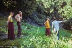 (39390_sl-3.jpg) Ann McNeil (Anila Ann), John Jackson, Lama Yeshe, and Rick Crangle surveying the land at Vajrapani Institute, California, 1978.